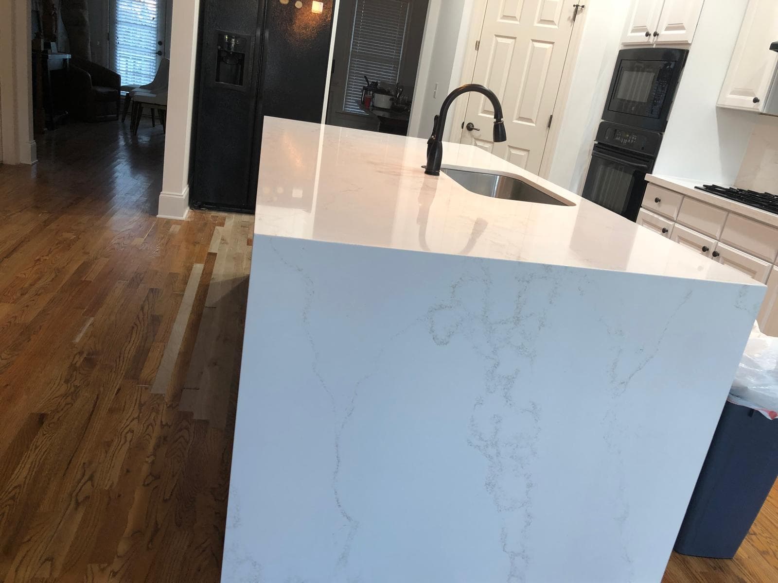 White quartz waterfall island with black faucet and undermount sink, Atlanta, GA